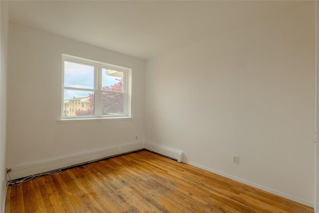 8 Florence Ave Unit 16C, Freeport, NY 11520 - spare room featuring light wood-style floors, baseboards, and a baseboard heating unit