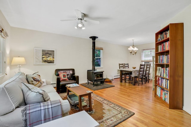 512 Watson Woods Rd, Woodstock, NY 12498 - living area featuring a wood stove, light wood-style floors, ceiling fan, a chandelier, and baseboard heating