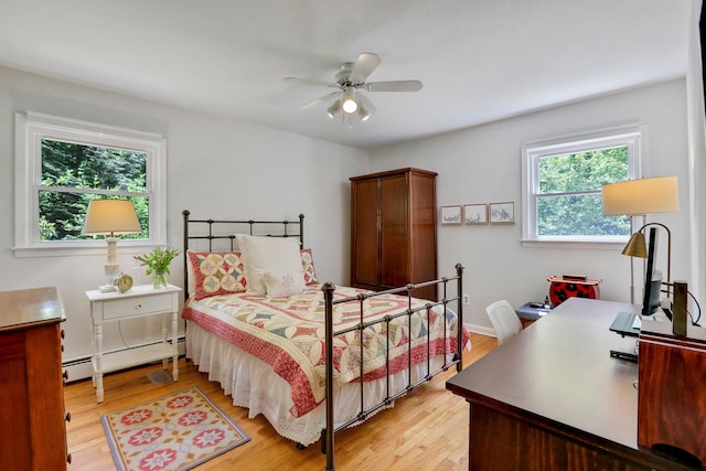 512 Watson Woods Rd, Woodstock, NY 12498 - bedroom featuring a baseboard radiator, light wood-style floors, a desk, and a ceiling fan