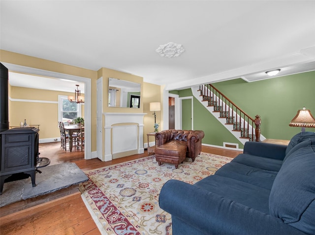 31 Hudson Ave, Stony Point, NY 10980 - living area with stairs, wood finished floors, a wood stove, and a chandelier