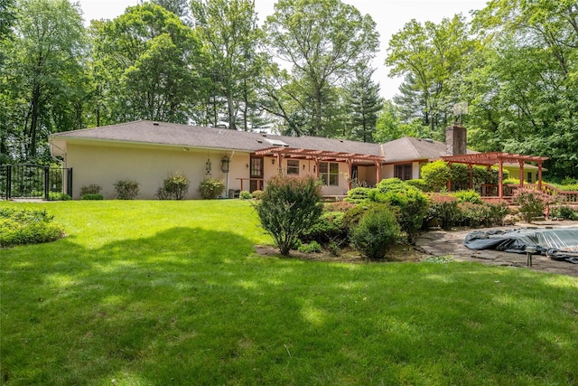 100 Foxhunt Cres, Oyster Bay Cove, NY 11791 - rear view of property featuring a pergola, a chimney, a yard, and stucco siding