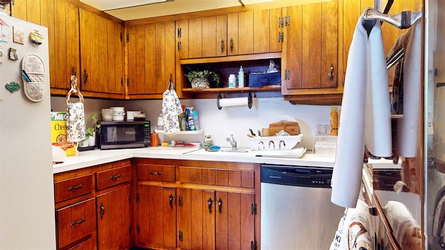 4 Christine Dr, Spring Valley, NY 10977 - kitchen featuring dishwasher, freestanding refrigerator, light countertops, brown cabinets, and a sink