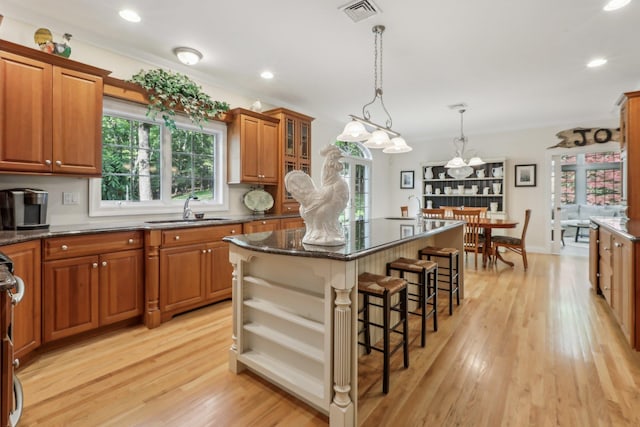 42 Panorama Dr, Warwick, NY 10990 - kitchen with a sink, a kitchen breakfast bar, a center island, brown cabinetry, and light wood-type flooring