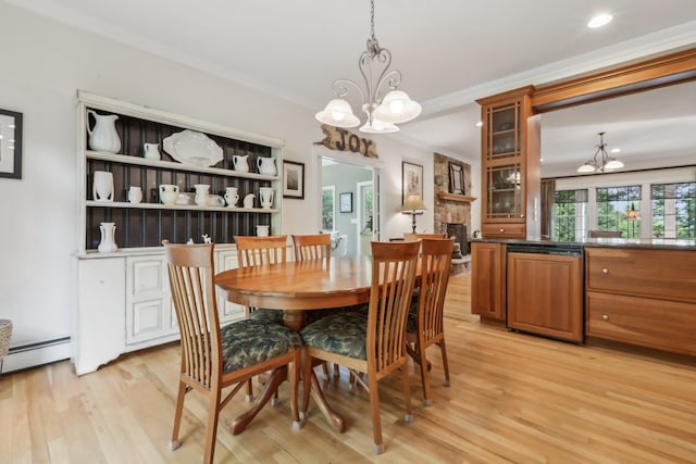 42 Panorama Dr, Warwick, NY 10990 - dining space with a chandelier, light wood-style flooring, crown molding, a baseboard heating unit, and a stone fireplace