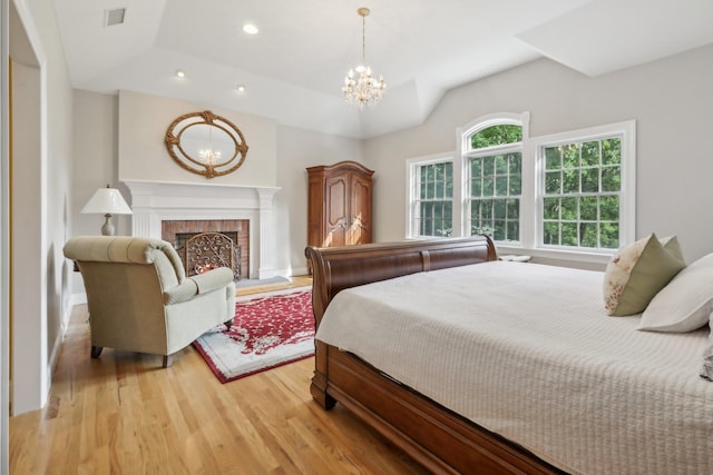 42 Panorama Dr, Warwick, NY 10990 - bedroom featuring light wood finished floors, a chandelier, recessed lighting, and a brick fireplace