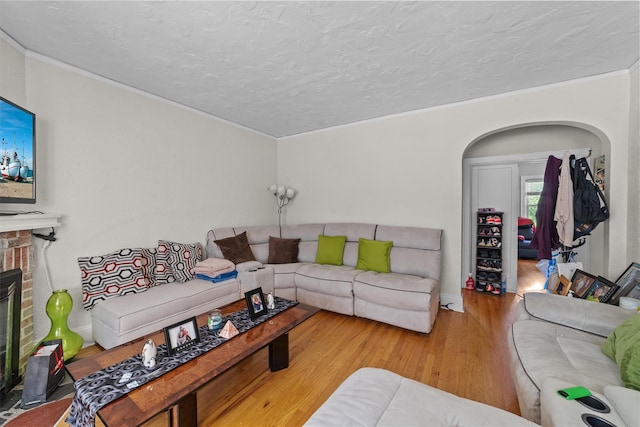 107 Underhill Ave, West Harrison, NY 10604 - living room with wood finished floors, crown molding, a brick fireplace, and a textured ceiling