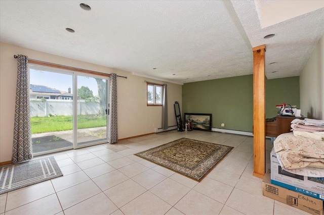 378 W Waukena Ave, Oceanside, NY 11572 - interior space featuring baseboard heating, a baseboard heating unit, a textured ceiling, and light tile patterned flooring