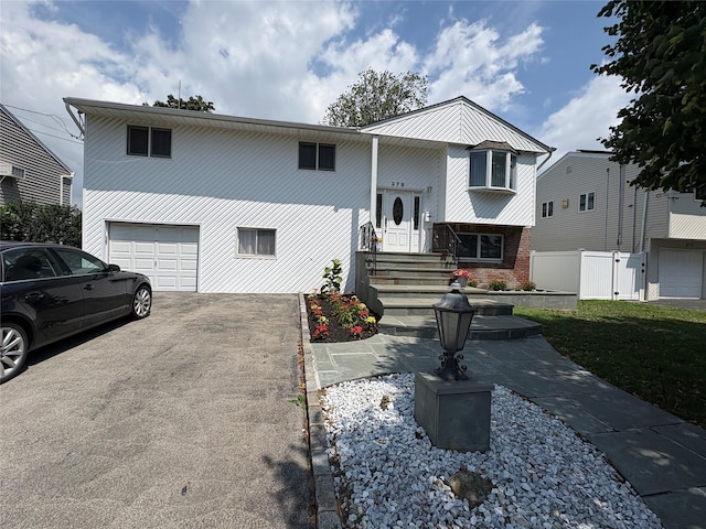 378 W Waukena Ave, Oceanside, NY 11572 - raised ranch with a garage, driveway, and brick siding