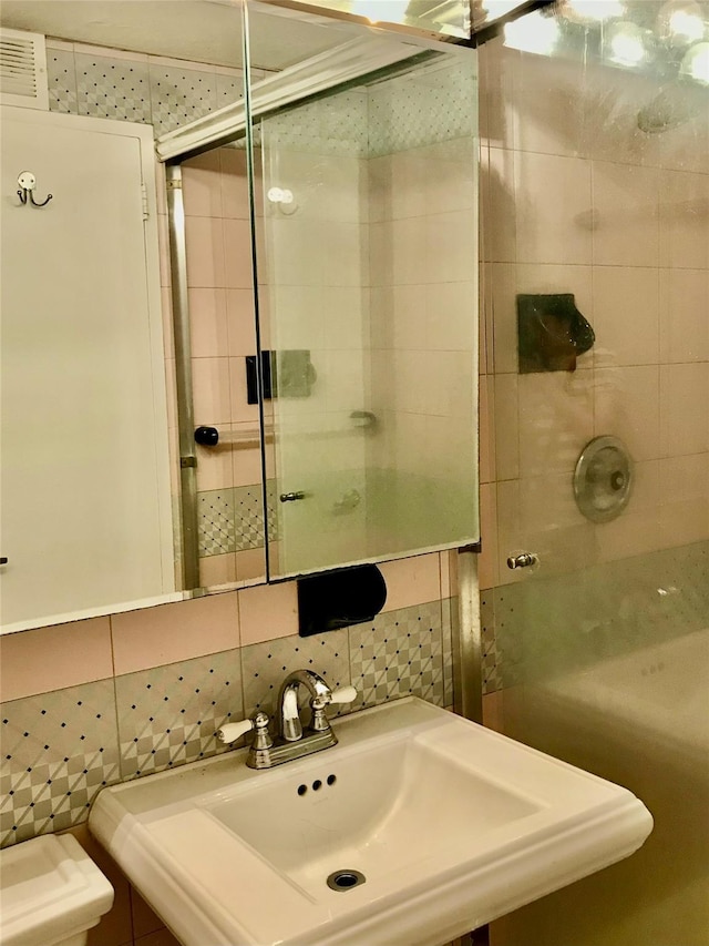150-38 Union Tpke Unit 4D, Flushing, NY 11367 - full bathroom featuring a tile shower, a sink, toilet, tile walls, and decorative backsplash