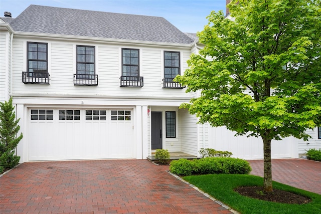 5 Rose Ln, Rye Brook, NY 10573 - view of front facade featuring decorative driveway, an attached garage, and a shingled roof