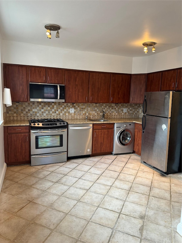 10 Welwyn Rd Unit 3E, Great Neck, NY 11021 - kitchen featuring appliances with stainless steel finishes, washer / dryer, decorative backsplash, and a sink
