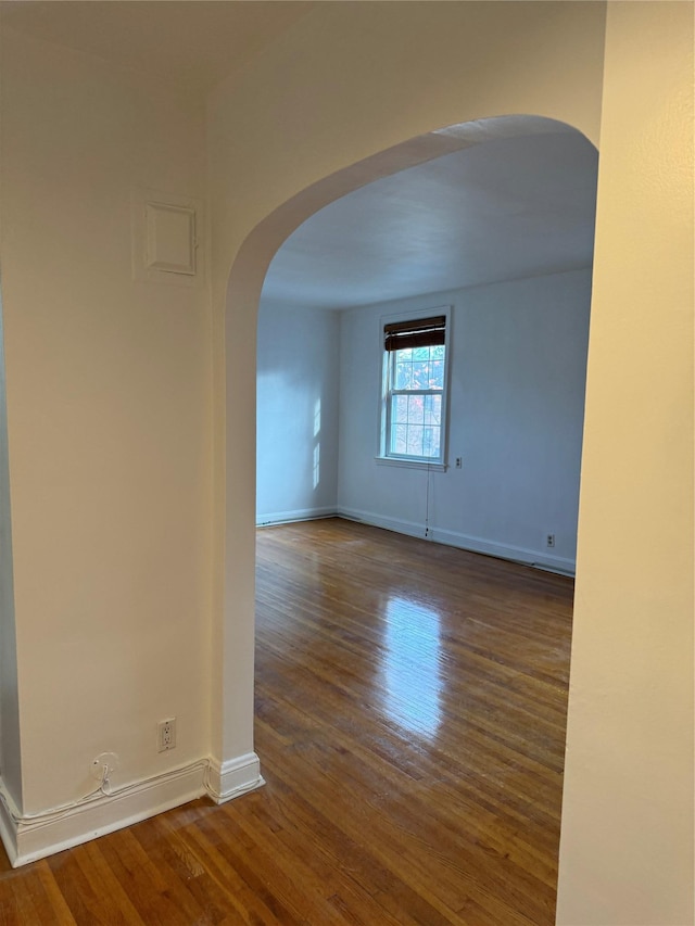 10 Welwyn Rd Unit 3E, Great Neck, NY 11021 - spare room with wood finished floors, arched walkways, and baseboards