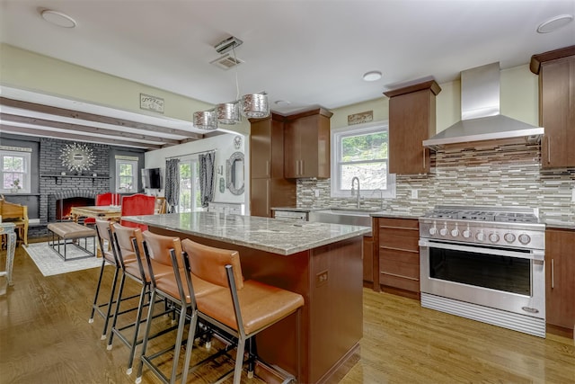 41 W Gate Rd, Suffern, NY 10901 - kitchen featuring high end range, wall chimney range hood, light stone counters, and light wood-style floors