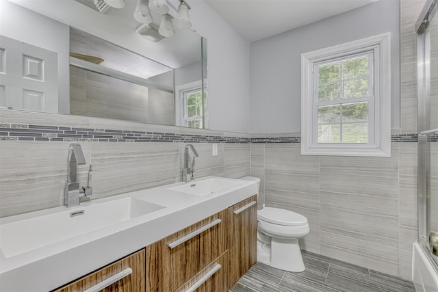 41 W Gate Rd, Suffern, NY 10901 - full bathroom with tile walls, double vanity, toilet, healthy amount of natural light, and enclosed tub / shower combo