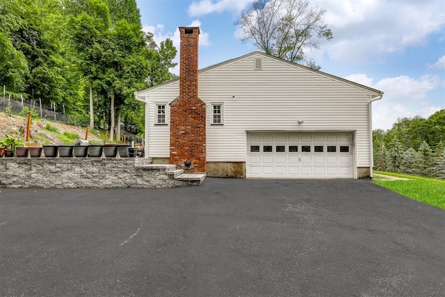 41 W Gate Rd, Suffern, NY 10901 - view of side of home featuring driveway, a chimney, and a garage