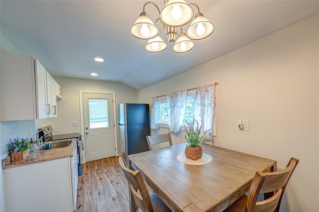 51 Franklin St, Brentwood, NY 11717 - dining space with light wood finished floors, a chandelier, vaulted ceiling, and recessed lighting