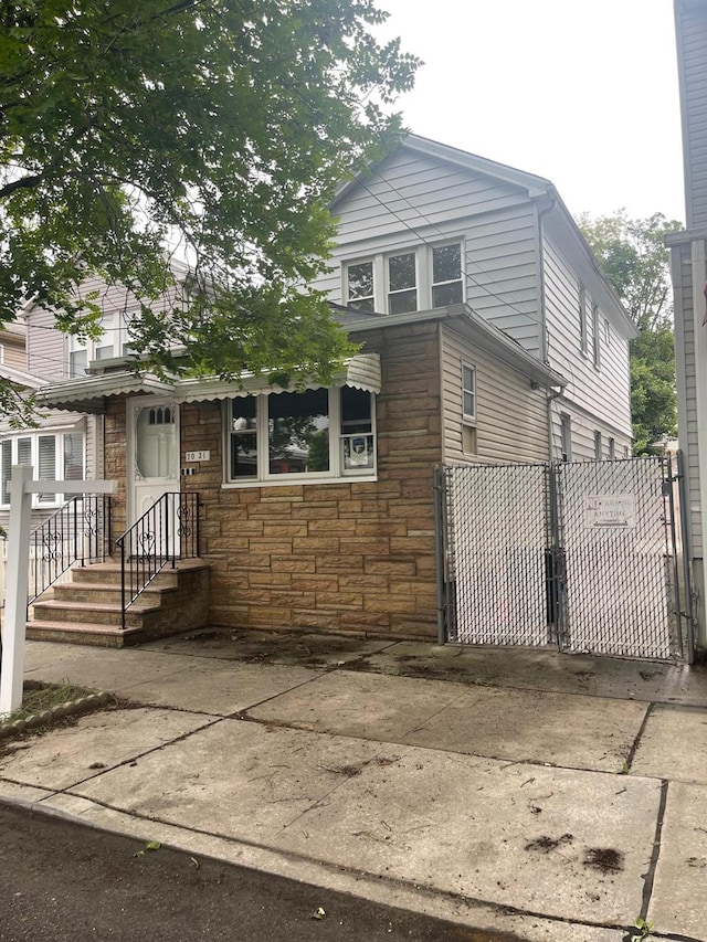 70-31 71st Pl, Glendale, NY 11385 - view of front of property with stone siding and a gate