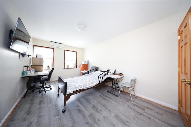 2366 E 29th St, Brooklyn, NY 11229 - bedroom with an AC wall unit, wood finished floors, a desk, and baseboards