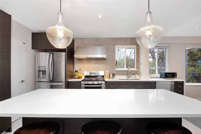 13915 Coolidge Ave, Briarwood, NY 11435 - kitchen with stainless steel appliances, wall chimney range hood, a sink, light countertops, and a kitchen breakfast bar