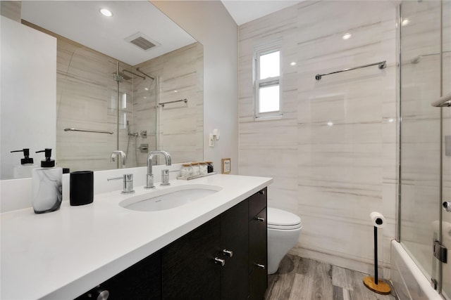 13915 Coolidge Ave, Briarwood, NY 11435 - full bath featuring vanity, wood finished floors, toilet, and bath / shower combo with glass door