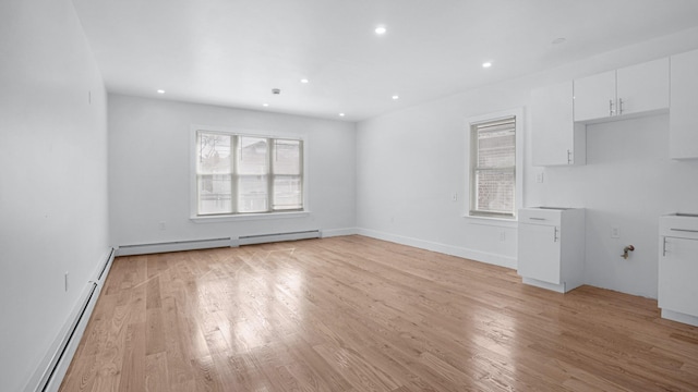 2825 Wellman Ave, Bronx, NY 10461 - unfurnished living room with plenty of natural light, a baseboard heating unit, light wood-style flooring, baseboard heating, and recessed lighting
