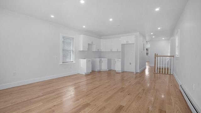 2825 Wellman Ave, Bronx, NY 10461 - unfurnished living room with a baseboard heating unit, recessed lighting, light wood-style flooring, and baseboards