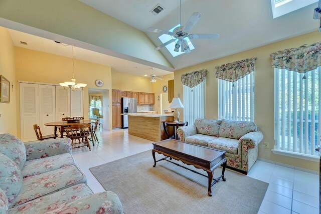 276 Dockside Ct, Moriches, NY 11955 - living room with light tile patterned floors, a skylight, a chandelier, a ceiling fan, and high vaulted ceiling