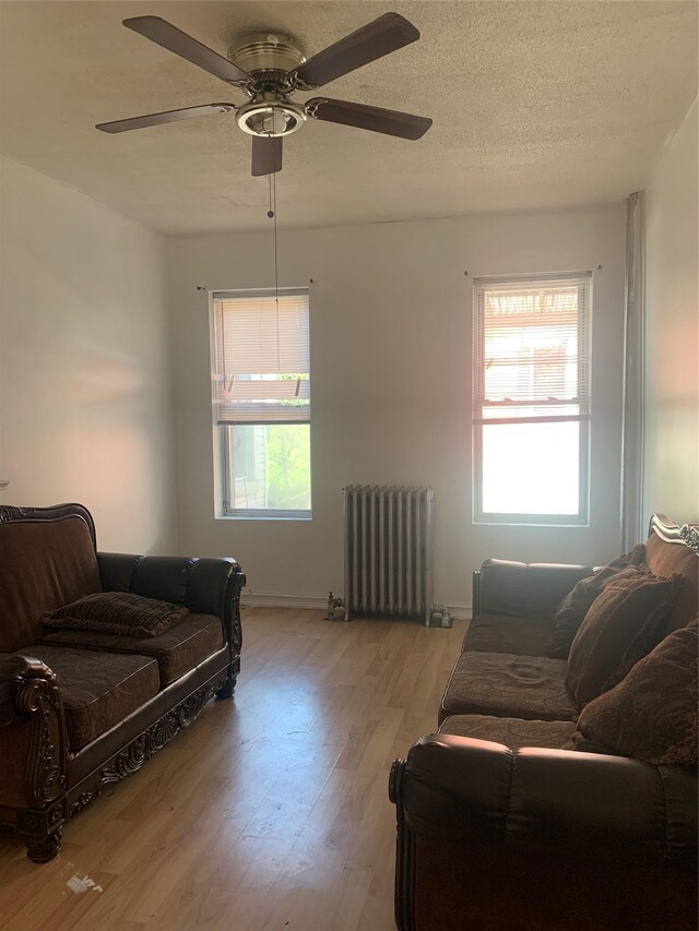 199 Lincoln Ave, Brooklyn, NY 11208 - living room with radiator, a ceiling fan, wood finished floors, and a textured ceiling