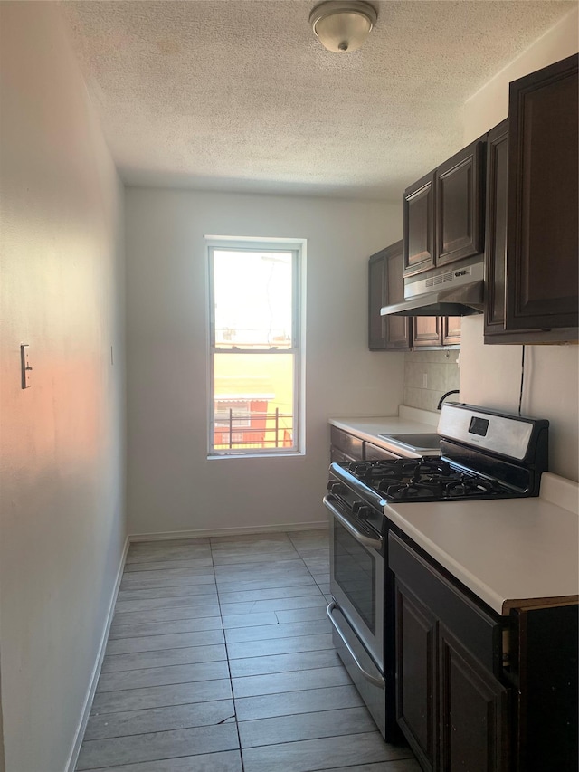199 Lincoln Ave, Brooklyn, NY 11208 - kitchen featuring stainless steel gas range oven, under cabinet range hood, light countertops, a textured ceiling, and backsplash