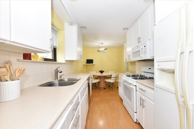 40 Stoner Ave Unit 1-I, Great Neck, NY 11021 - kitchen featuring white appliances, a sink, decorative backsplash, and light wood finished floors