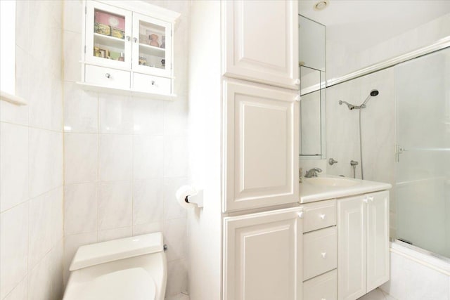 40 Stoner Ave Unit 1-I, Great Neck, NY 11021 - bathroom with toilet, a stall shower, vanity, and tile walls
