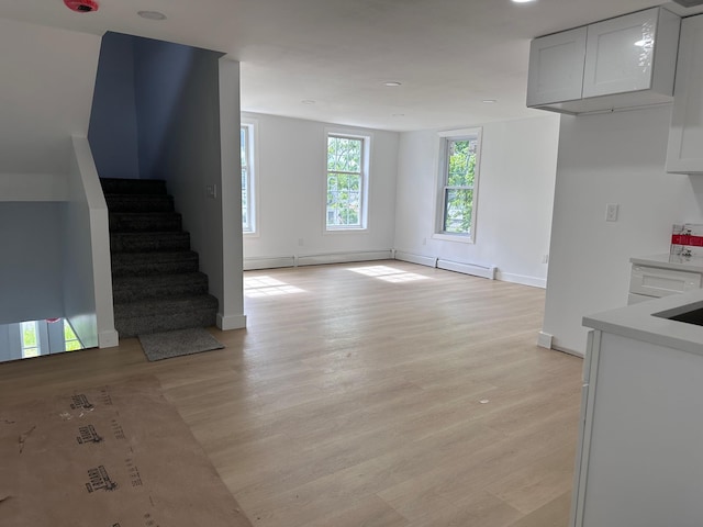 19 N Rd, Highland, NY 12528 - unfurnished living room featuring light wood-style flooring, stairs, a baseboard radiator, baseboards, and recessed lighting