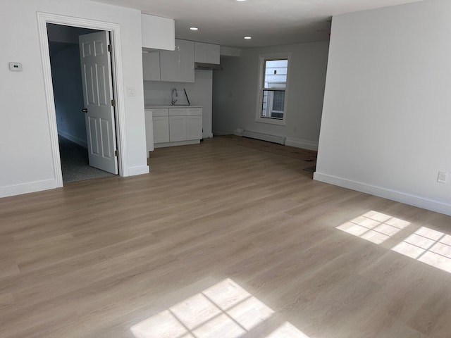 19 N Rd, Highland, NY 12528 - unfurnished living room with a baseboard radiator, baseboards, light wood-style floors, a sink, and recessed lighting