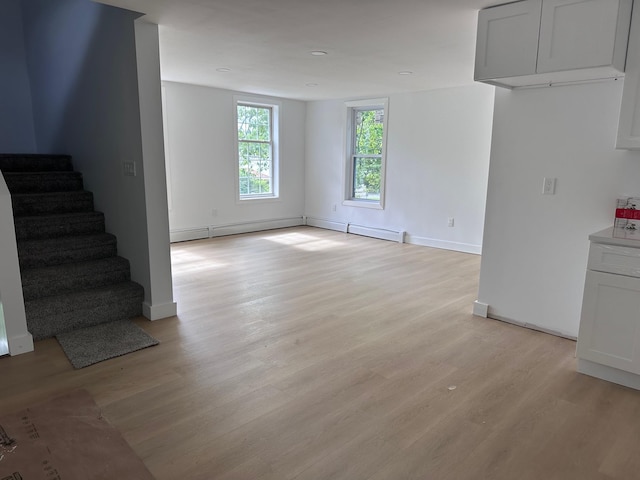 19 N Rd, Highland, NY 12528 - unfurnished living room featuring light wood-style flooring, stairs, baseboards, and a baseboard heating unit
