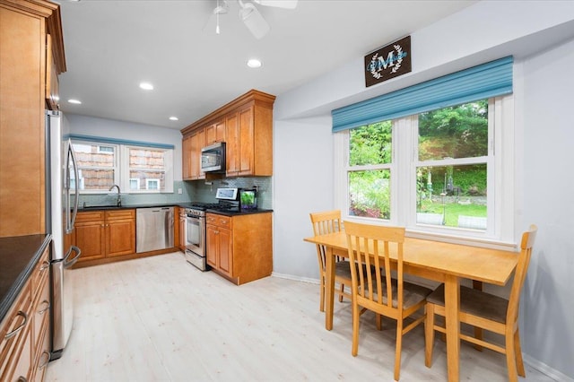 71 Harlan Dr, New Rochelle, NY 10804 - kitchen with appliances with stainless steel finishes, dark countertops, brown cabinetry, light wood finished floors, and recessed lighting