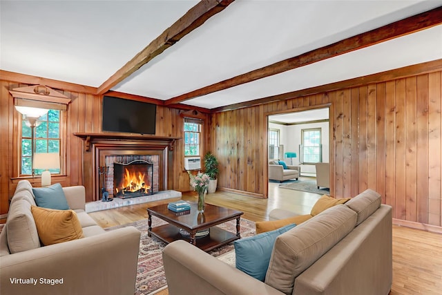 14 Wainscott Ln, East Setauket, NY 11733 - living room with beamed ceiling, a warm lit fireplace, wood walls, wood finished floors, and cooling unit