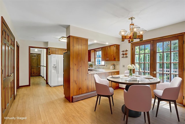 14 Wainscott Ln, East Setauket, NY 11733 - dining area featuring a baseboard heating unit, light wood-style flooring, baseboards, and a chandelier