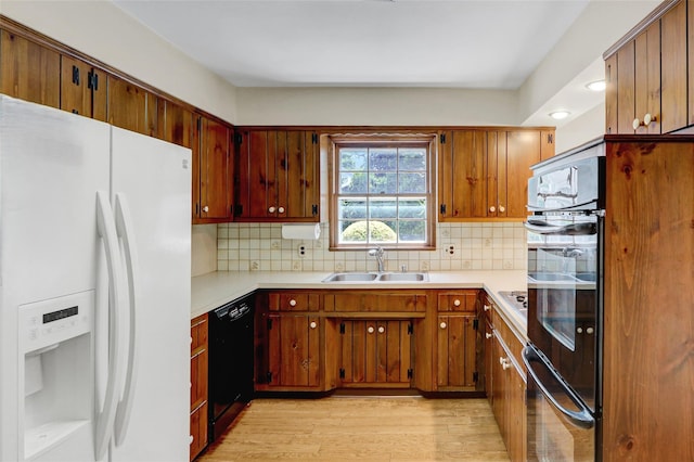 14 Wainscott Ln, East Setauket, NY 11733 - kitchen featuring black appliances, a sink, light wood-type flooring, and light countertops