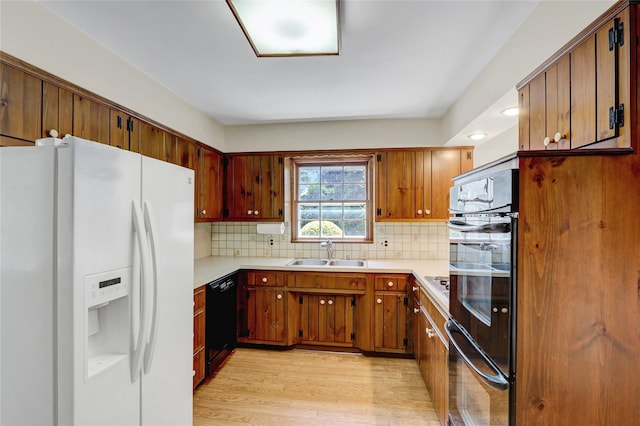 14 Wainscott Ln, East Setauket, NY 11733 - kitchen with black appliances, a sink, light wood-type flooring, and light countertops