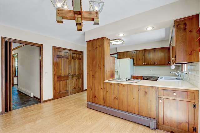 14 Wainscott Ln, East Setauket, NY 11733 - kitchen featuring a baseboard radiator, white appliances, a sink, a baseboard heating unit, and light countertops