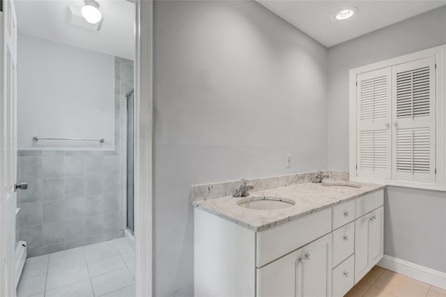 14 Wainscott Ln, East Setauket, NY 11733 - full bath featuring a shower stall, tile patterned flooring, double vanity, baseboards, and a baseboard radiator