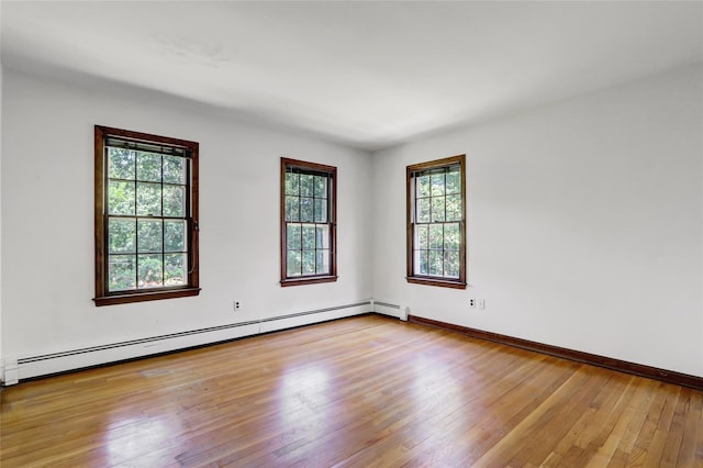 14 Wainscott Ln, East Setauket, NY 11733 - empty room featuring baseboard heating, hardwood / wood-style flooring, and baseboards