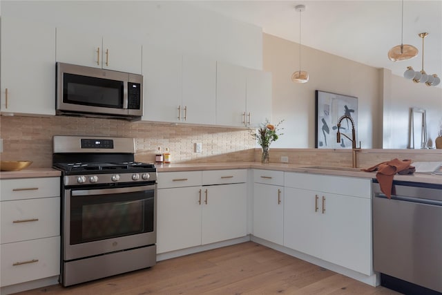 249 Main St Unit 401, Beacon, NY 12508 - kitchen with appliances with stainless steel finishes, a sink, light countertops, tasteful backsplash, and white cabinets