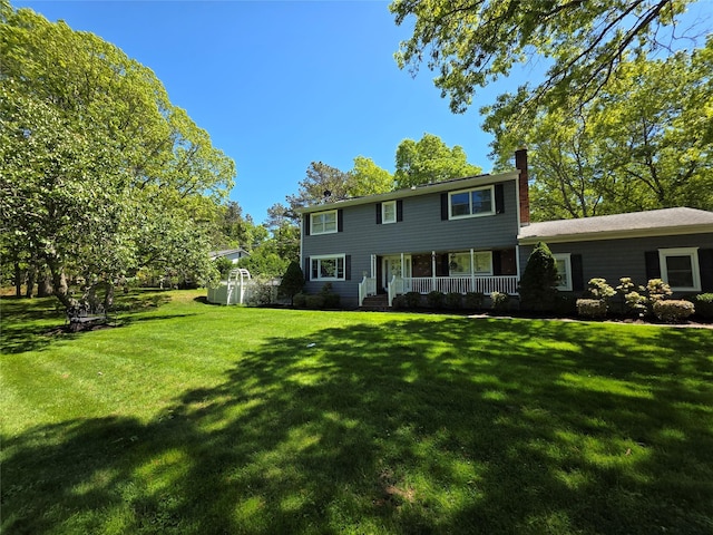 81 Anchor St, Riverhead, NY 11901 - view of front of house with a chimney, a porch, and a front lawn