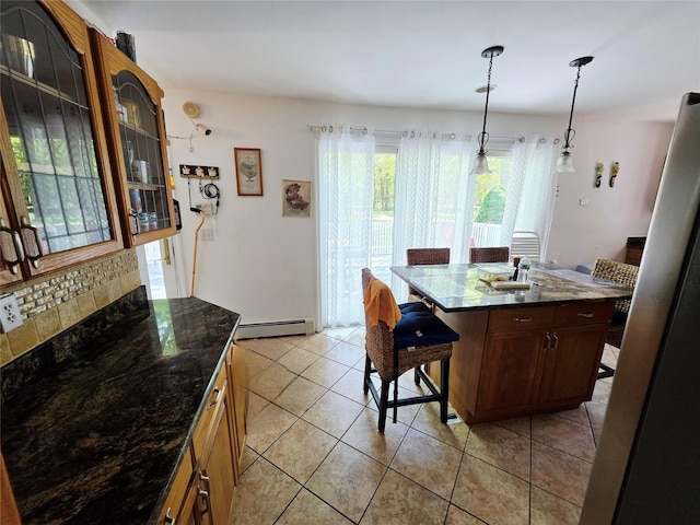 81 Anchor St, Riverhead, NY 11901 - kitchen featuring a baseboard radiator, a kitchen breakfast bar, light tile patterned floors, glass insert cabinets, and pendant lighting