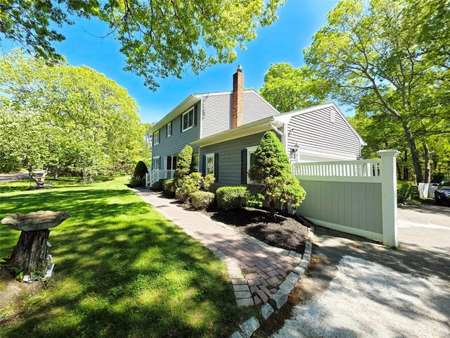 81 Anchor St, Riverhead, NY 11901 - view of property exterior featuring a lawn and a chimney