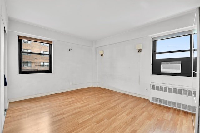 3343 14th St Unit 12B, Astoria, NY 11106 - empty room featuring radiator, healthy amount of natural light, light wood-type flooring, and baseboards