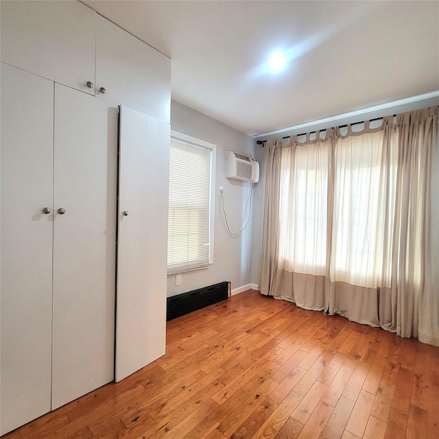 40-19 68th St, Woodside, NY 11377 - unfurnished bedroom with a wall mounted air conditioner, light wood-style floors, and a closet