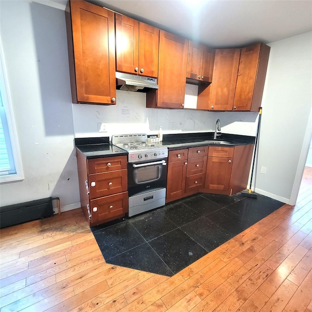 40-19 68th St, Woodside, NY 11377 - kitchen featuring gas stove, under cabinet range hood, dark countertops, and dark wood-type flooring