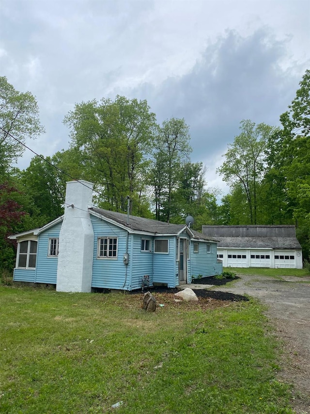 2411 Goshen Tpke, Middletown, NY 10941 - view of front of property featuring a front yard, a garage, a chimney, and view of scattered trees